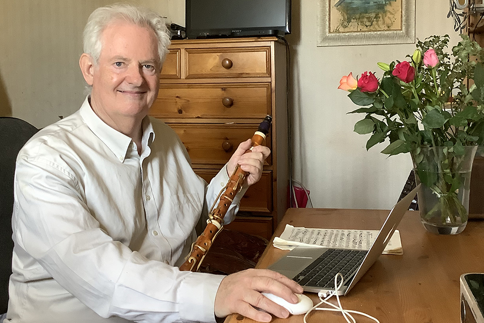 Professor Colin Lawson CBE FRCM with his clarinet and his laptop at home